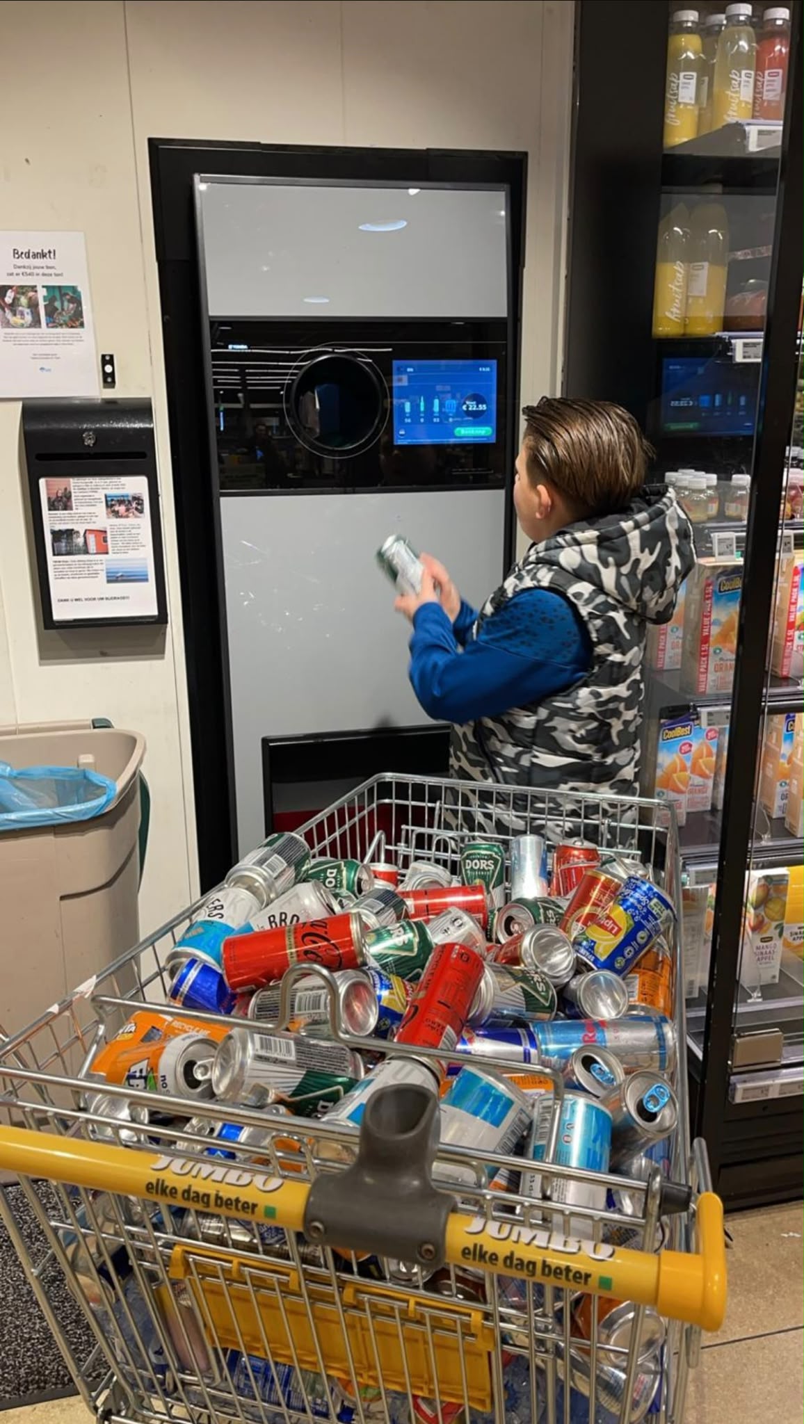 Jermain levert een volle winkelwagen met statiegeldblikjes en flessen in bij de supermarkt.